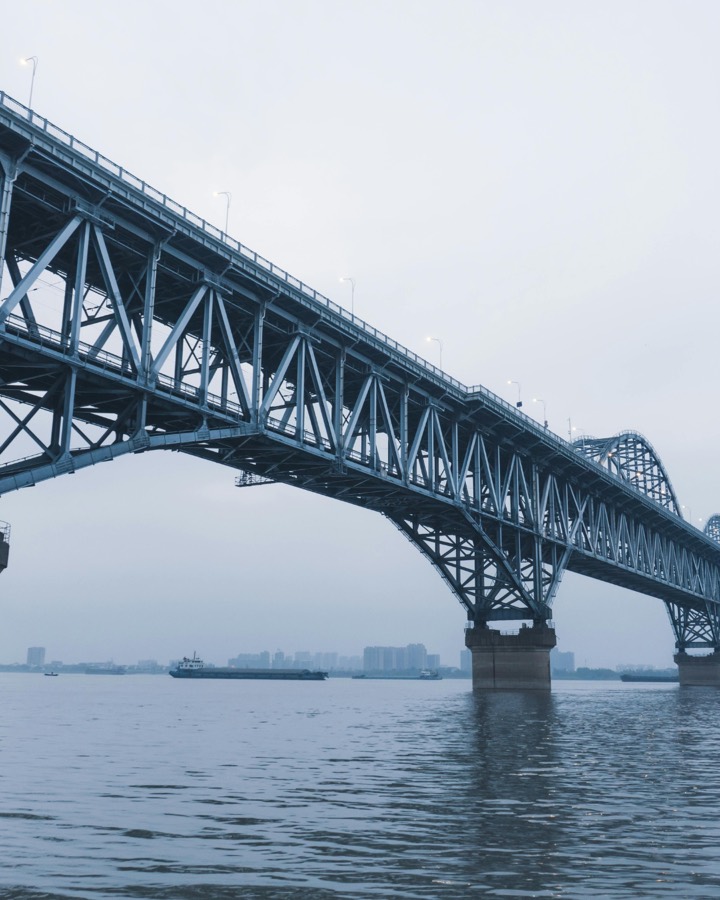 Ponte de estrutura metálica sobre o rio, simbolizando a estrutura que conecta as frentes